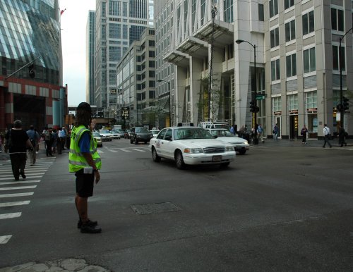 A woman helps direct traffic even though there were traffic lights there. Chicago (2007)