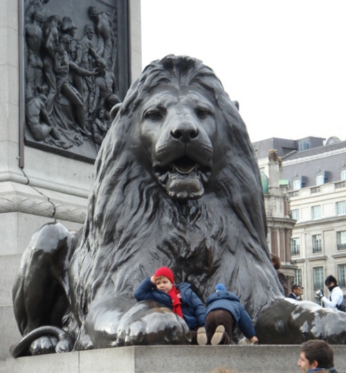 Some kids having fun climbing on the Lions in Leicester Square, London (2006)